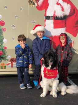 Children posing in front of a Santa painted on one of Pete and Pete Inc.'s dumpsters 