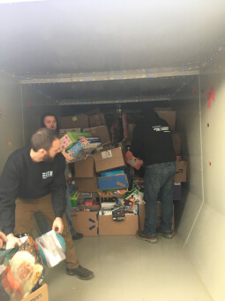 The team at Pete and Pete Inc. filling a container with donated holiday gifts.
