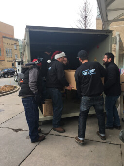 The team at Pete and Pete Inc. filling a container with donated gifts.