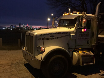 Roll off dumpster truck from Pete & Pete overlooking the nighttime Cleveland skyline